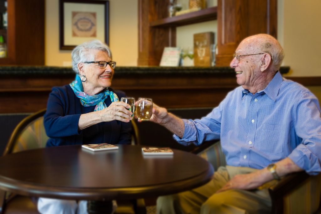 retirement home couple toasting with wine